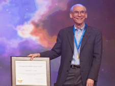 Ed Stone, the project scientist of NASA's Voyager mission, stands with his NASA Distinguished Public Service Medal and accompanying certificate. He received the award on the talk show The Colbert Report on Dec. 3, 2013.