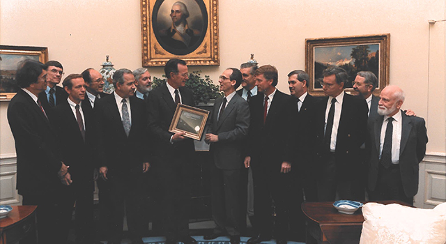 Voyager Project Scientist Ed Stone and other mission team members gave a framed copy of an iconic Voyager 1 solar system image that includes Earth as a "Pale Blue Dot" to President George H.W. Bush on June 7, 1990. The presentation was made at the White House in the Oval Office. Pictured L-R: Stamatios K. (tom) Krimgis, Barney J Conrath, Norman R. Haynes, Richard P. Laeser, George P. Textor, Lennard A. Fisk, Pres. George H.W. Bush, Edward C. Stone, Raymond L. Heacock, Earle T. Huckins, Esker K. (Ek) Davis, Adm. Richard H. Truly, Rudolf A. Hanal.