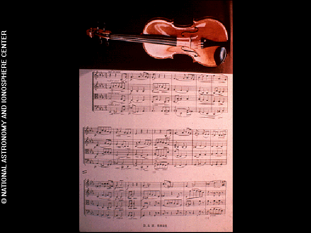 The violin with music score (Cavatina) image is one of the pictures electronically placed on the phonograph records which are carried onboard the Voyager 1 and 2 spacecraft. Credit: National Astronomy and Ionosphere Center, Cornell University (NAIC)